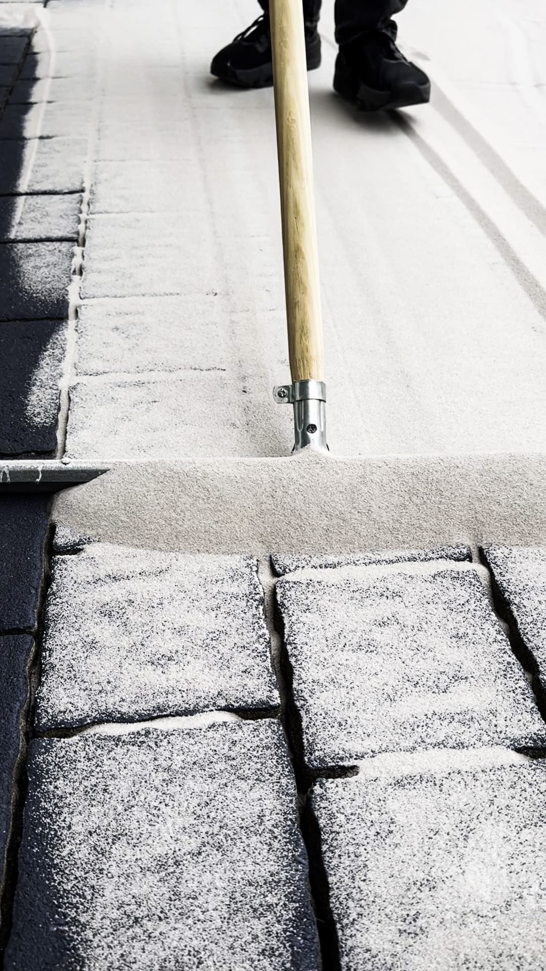 Fugenmaterial wird in die gereinigte Pflasterfläche eingearbeitet.
